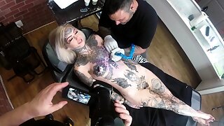 Sascha plays with Amber Luke while she gets tattooed